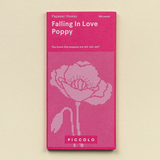 Pink seed packet for 'Falling in Love Poppy' with white text and flower illustration on a beige background