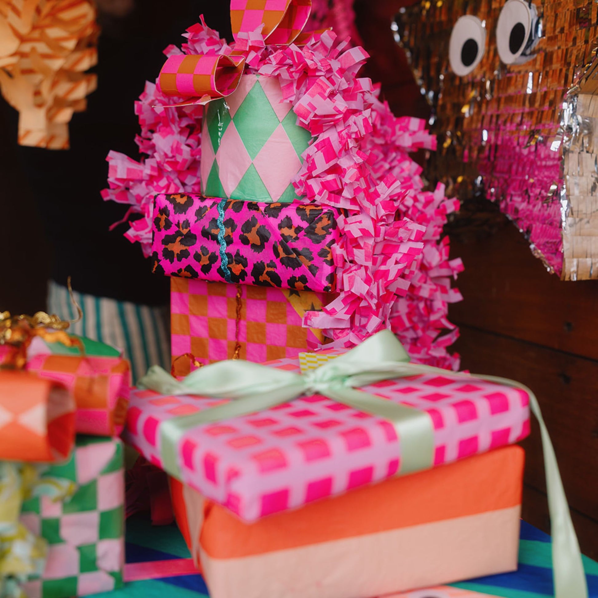 Christmas gifts wrapped in colourful luxury tissue papers with decorative ribbons.