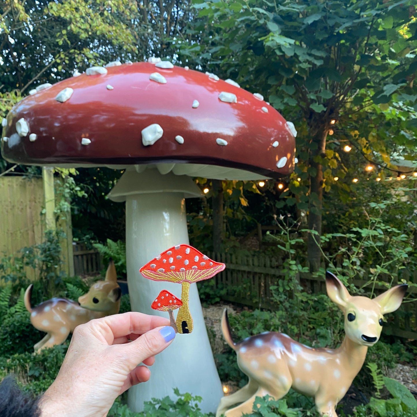 Toadstool iron on patch next to large toadstool ornament. 