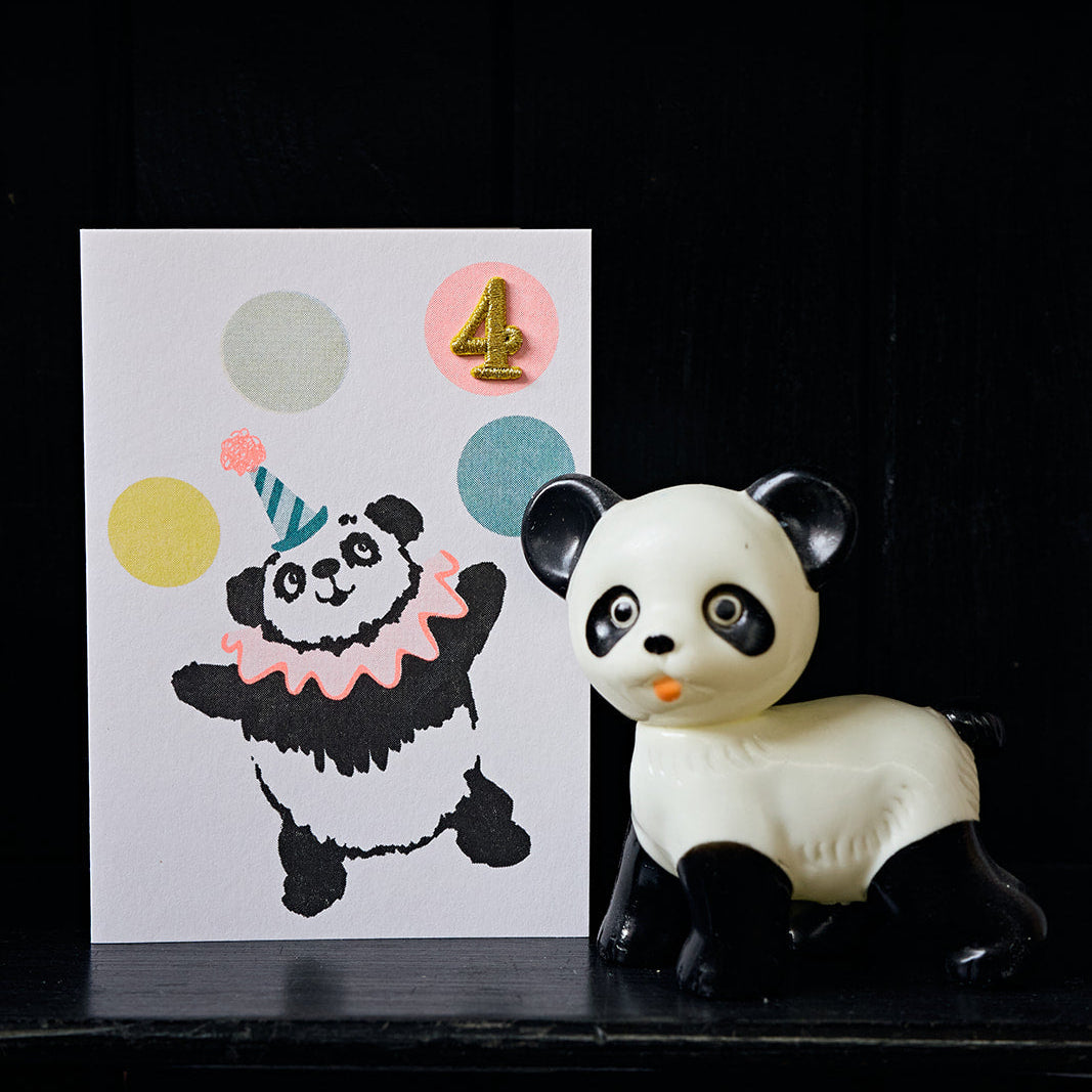 Panda-themed birthday card with colorful balloons and a panda figurine on a black background