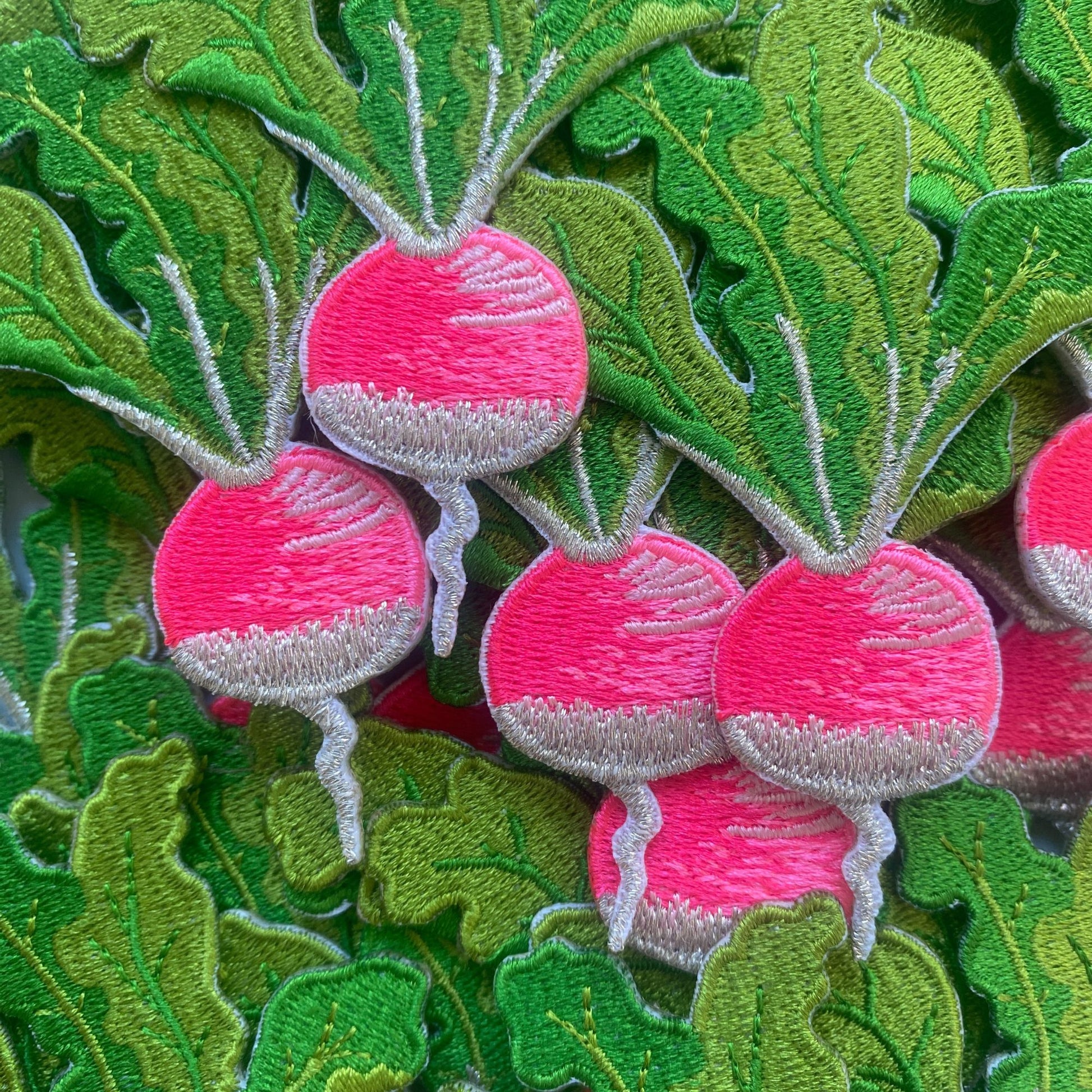 Embroidered radish iron on fabric patch.